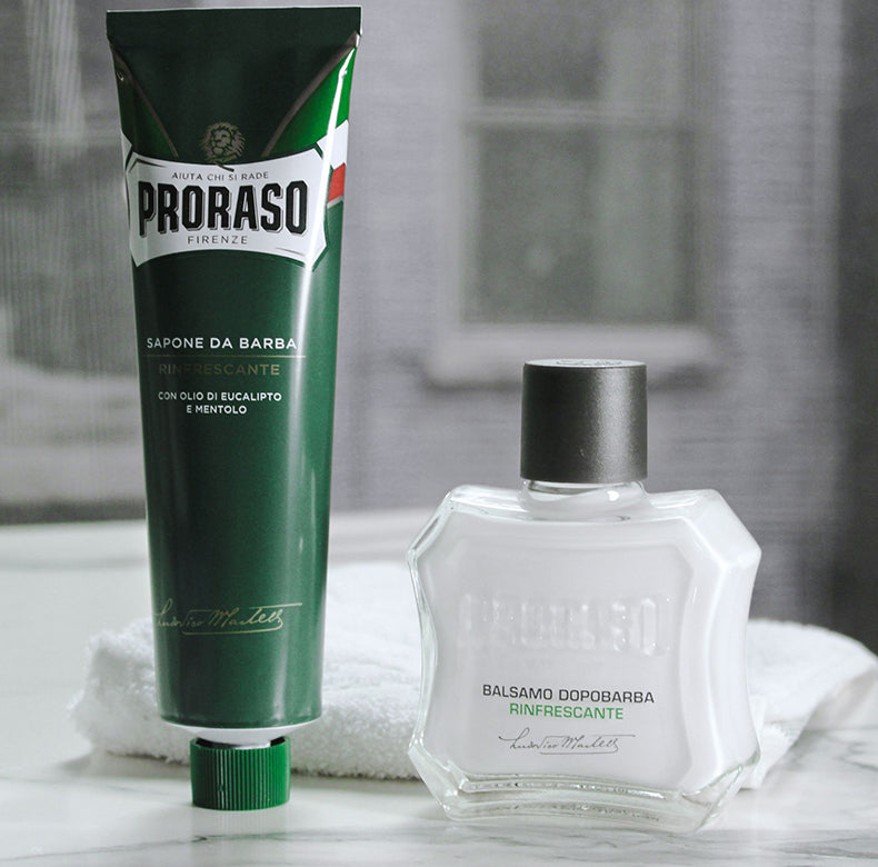 Tube of Refreshing Shave Cream Tube and After Shave Balm sitting on counter with a white towel in the background in front of a window 