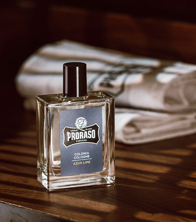Azur Lime Cologne sitting on wooden table with towel in background